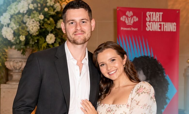 Tom Leach standing with his wife Mia McKenna-Bruce at a formal public event.